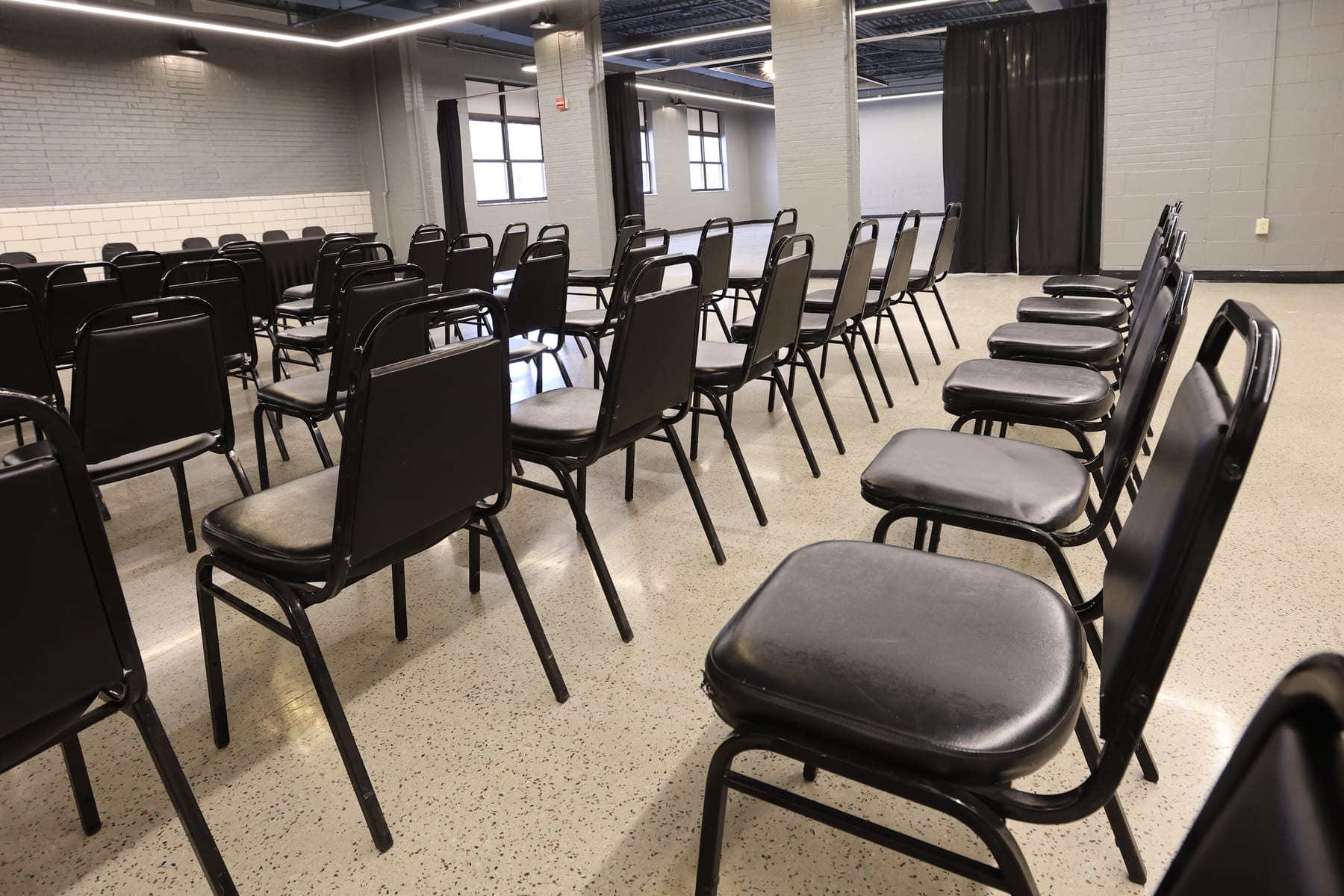 Black chairs in rows along the window wall