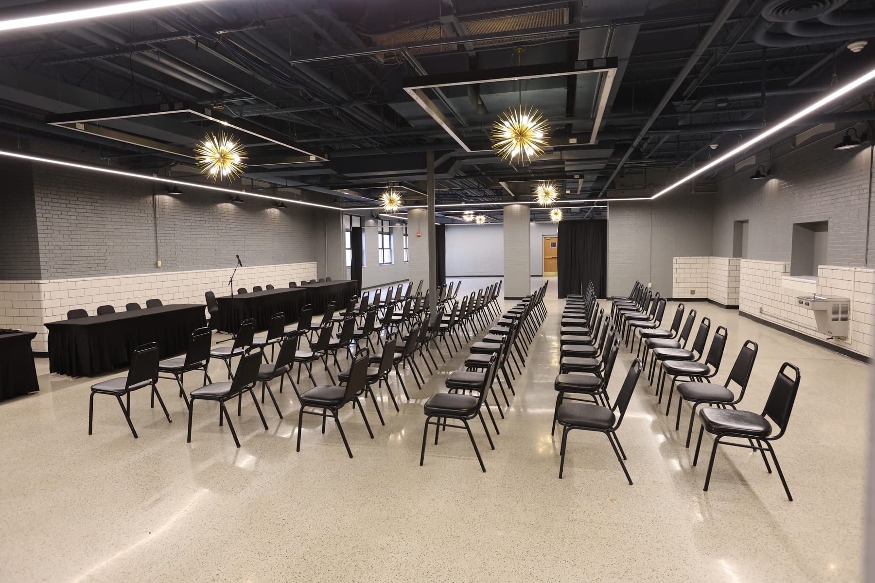 Theater rows and head tables from above, the window wall beyond