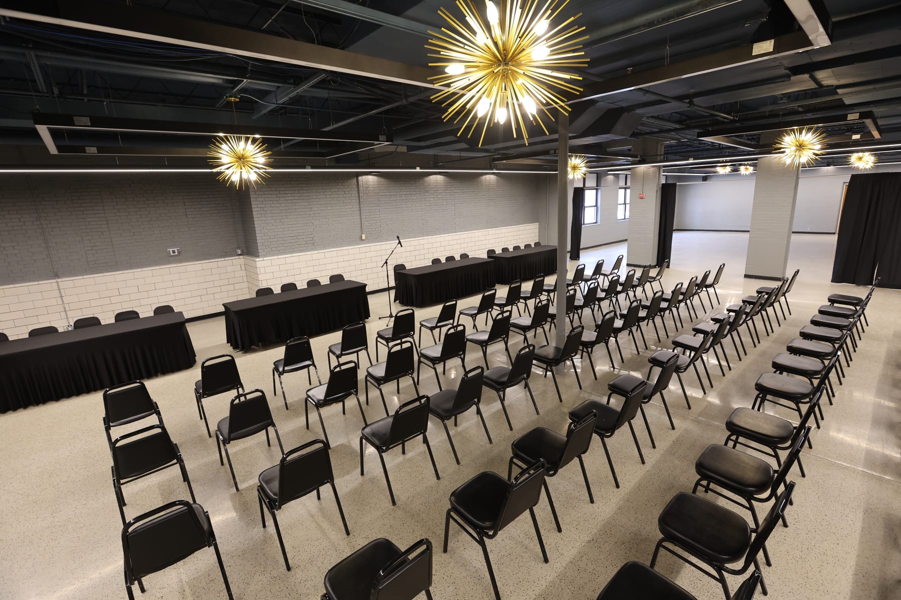 The Event Center set theater-style beneath its starburst chandeliers, head tables at the front