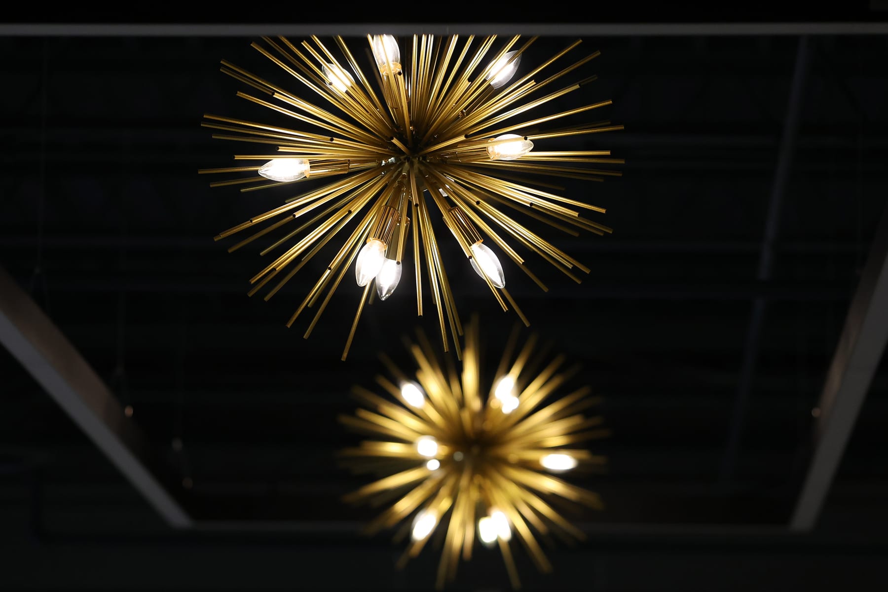 The brass starburst chandeliers above the Event Center floor